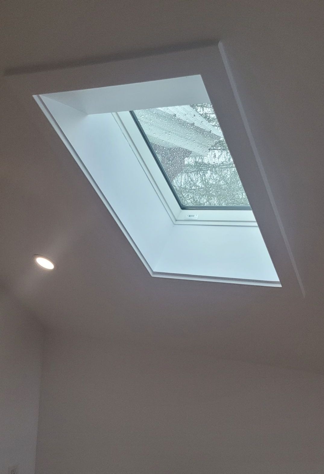 Il y a une lucarne au plafond d'une pièce.