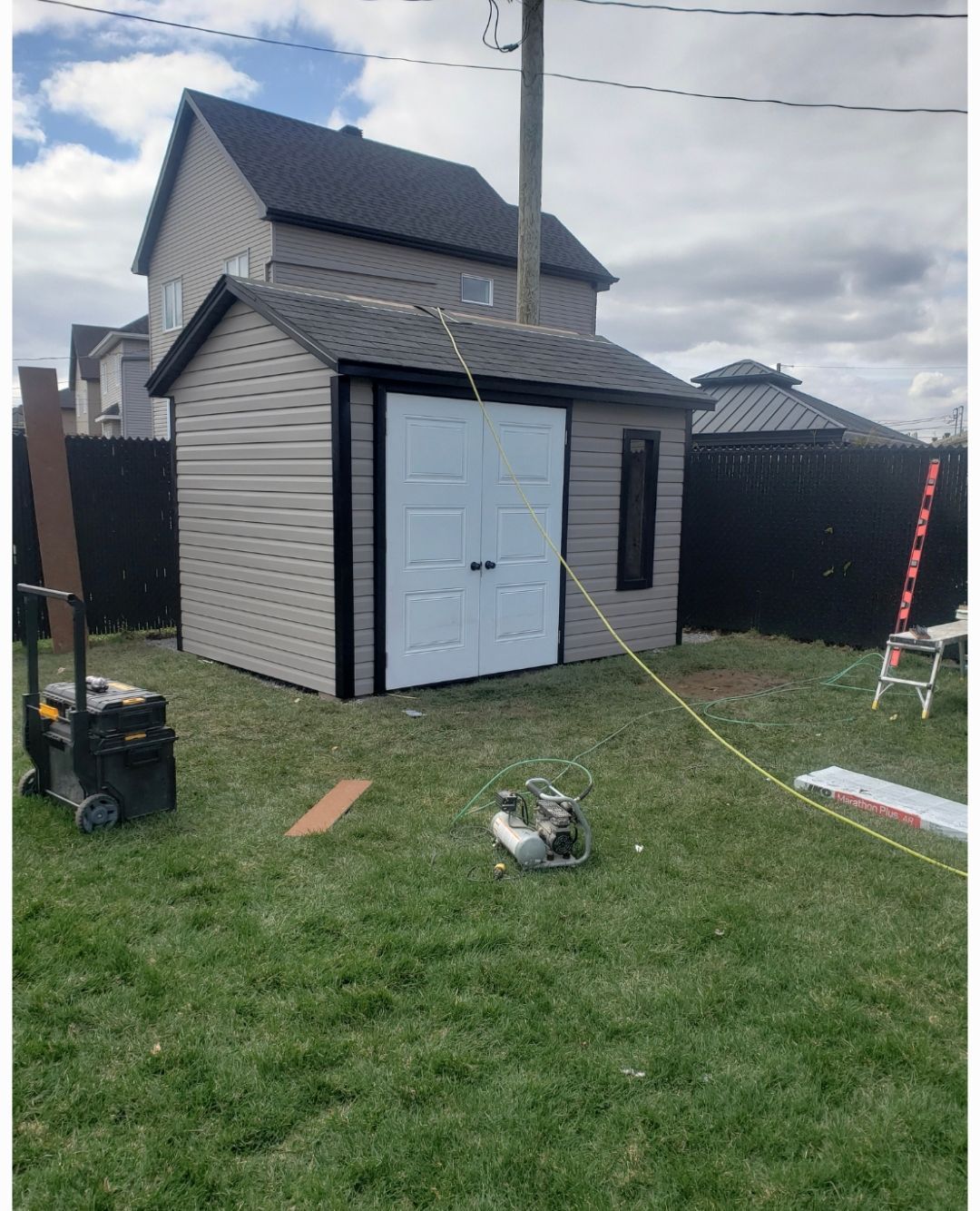 Un hangar est en cours de construction dans l'arrière-cour d'une maison.
