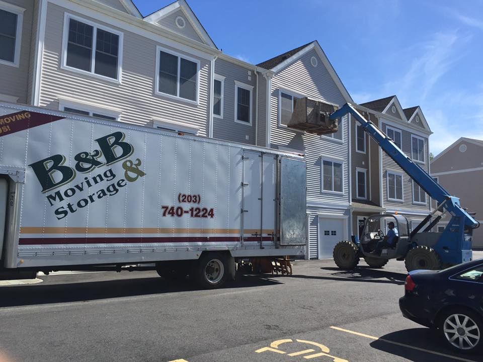 A b & b moving and storage truck is parked in front of a building