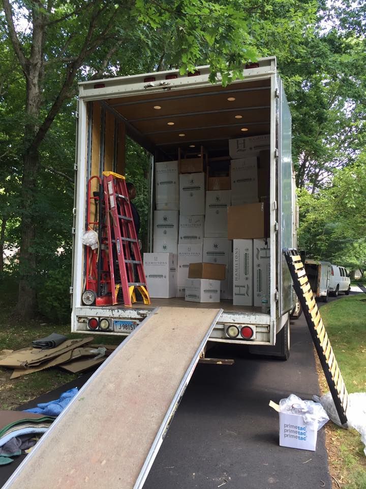 A moving truck is loaded with boxes and a ladder.