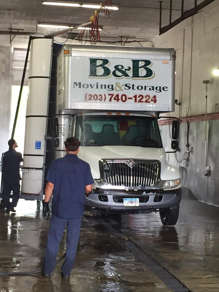 A man is walking towards a b & b moving & storage truck