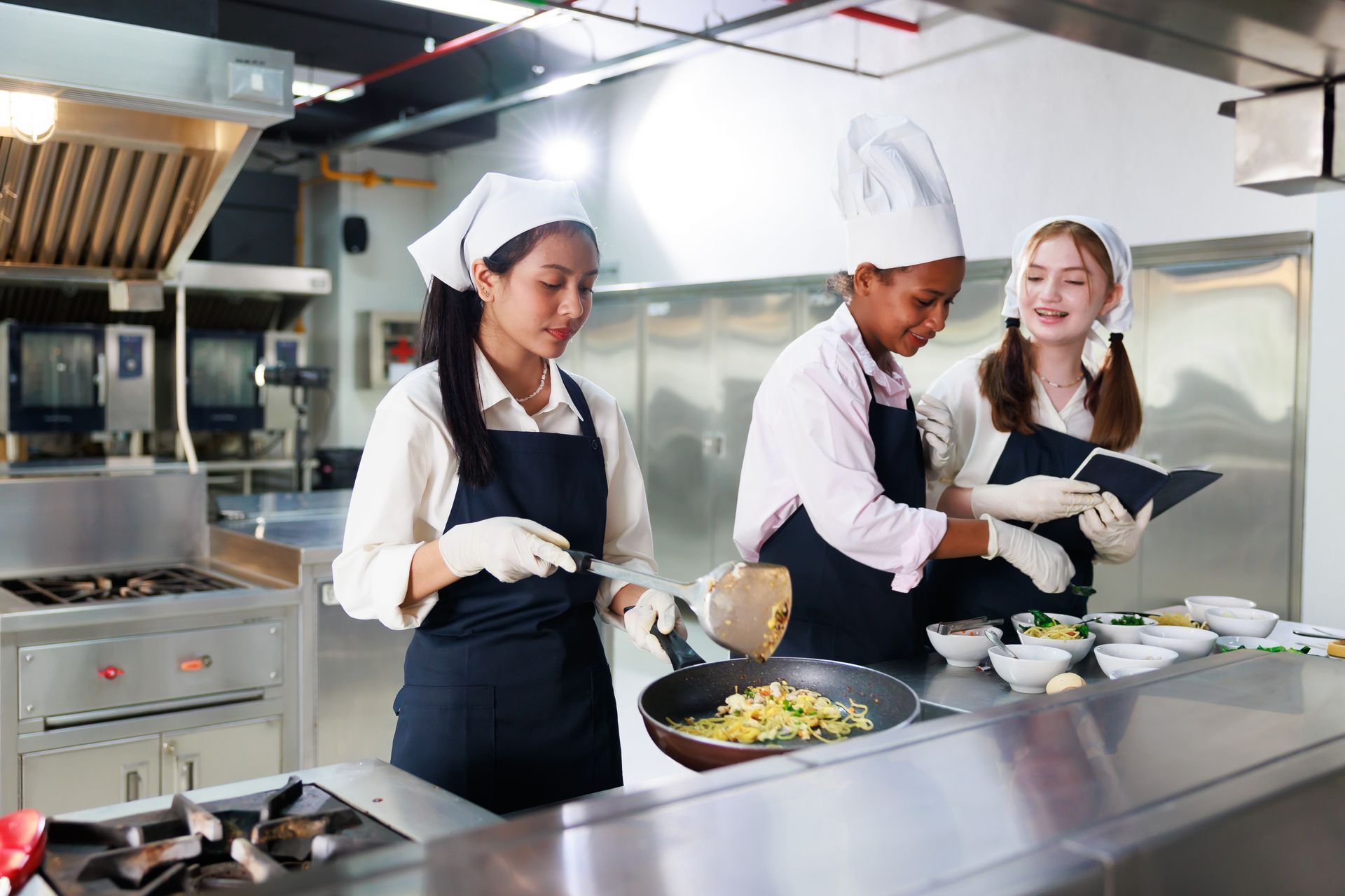 A group of young women are cooking in a kitchen.