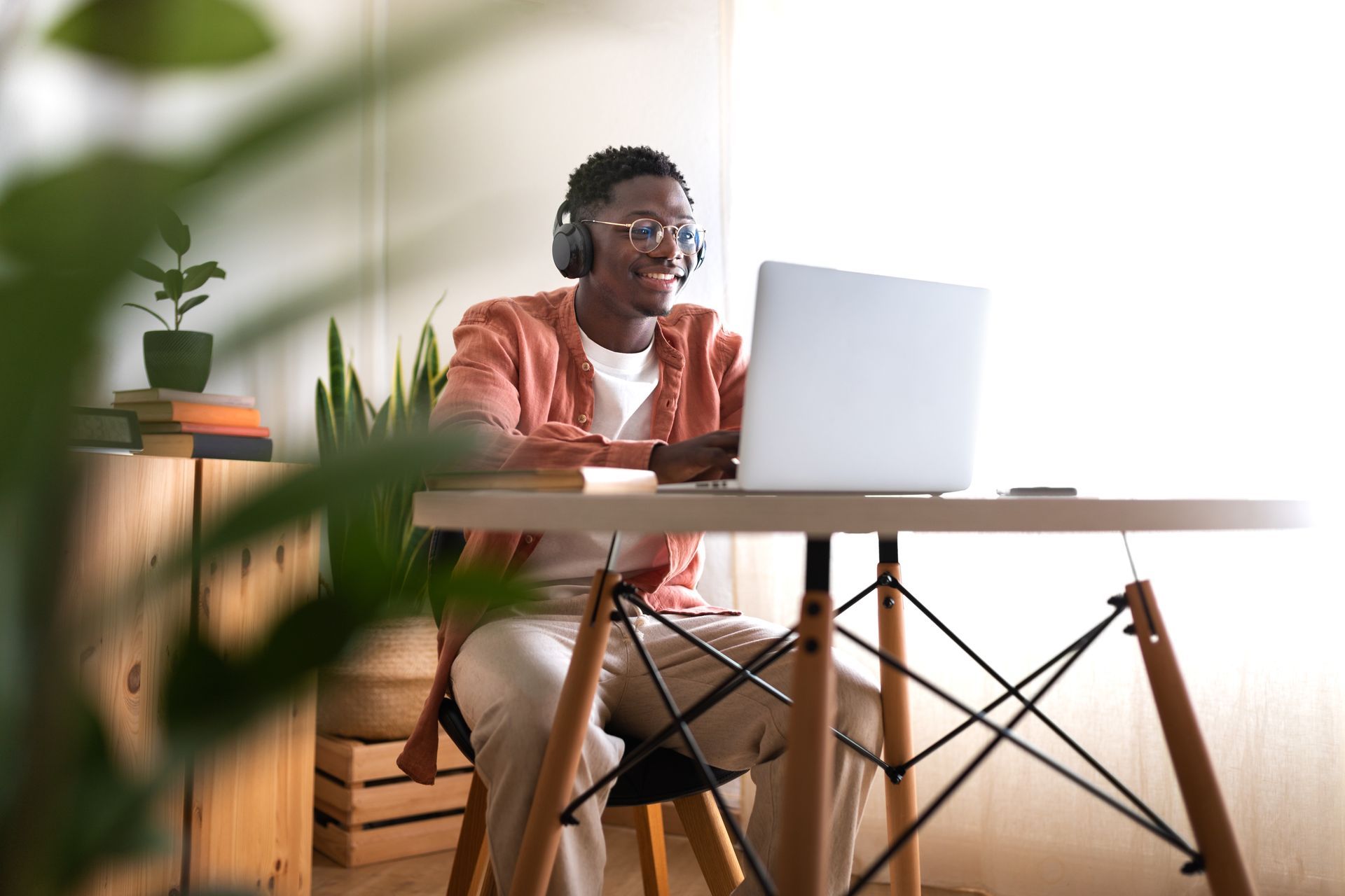 A man is sitting at a desk using a laptop computer.