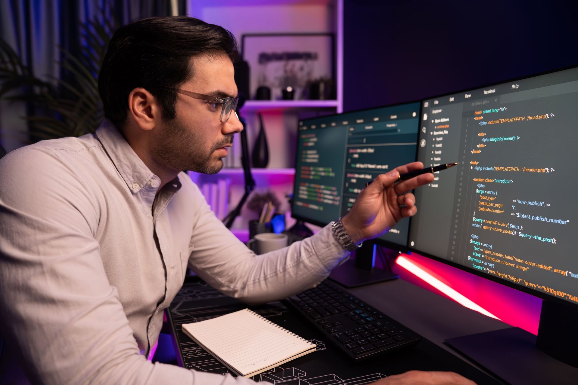 A man is sitting at a desk looking at a computer screen.