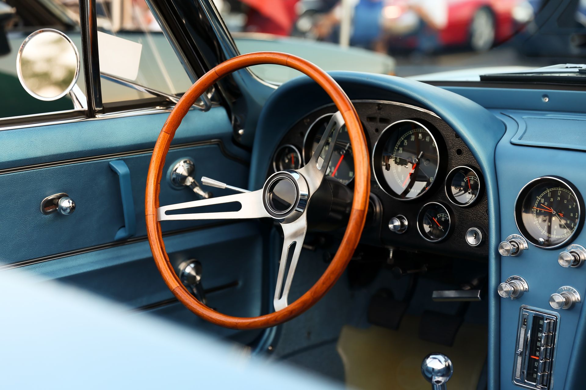 The interior of a blue car with a wooden steering wheel
