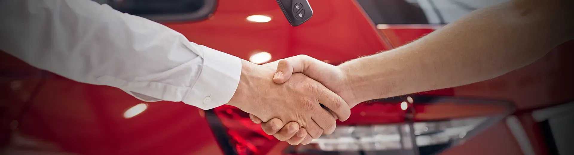Um homem está fazendo sinal de positivo enquanto está sentado em um carro.
