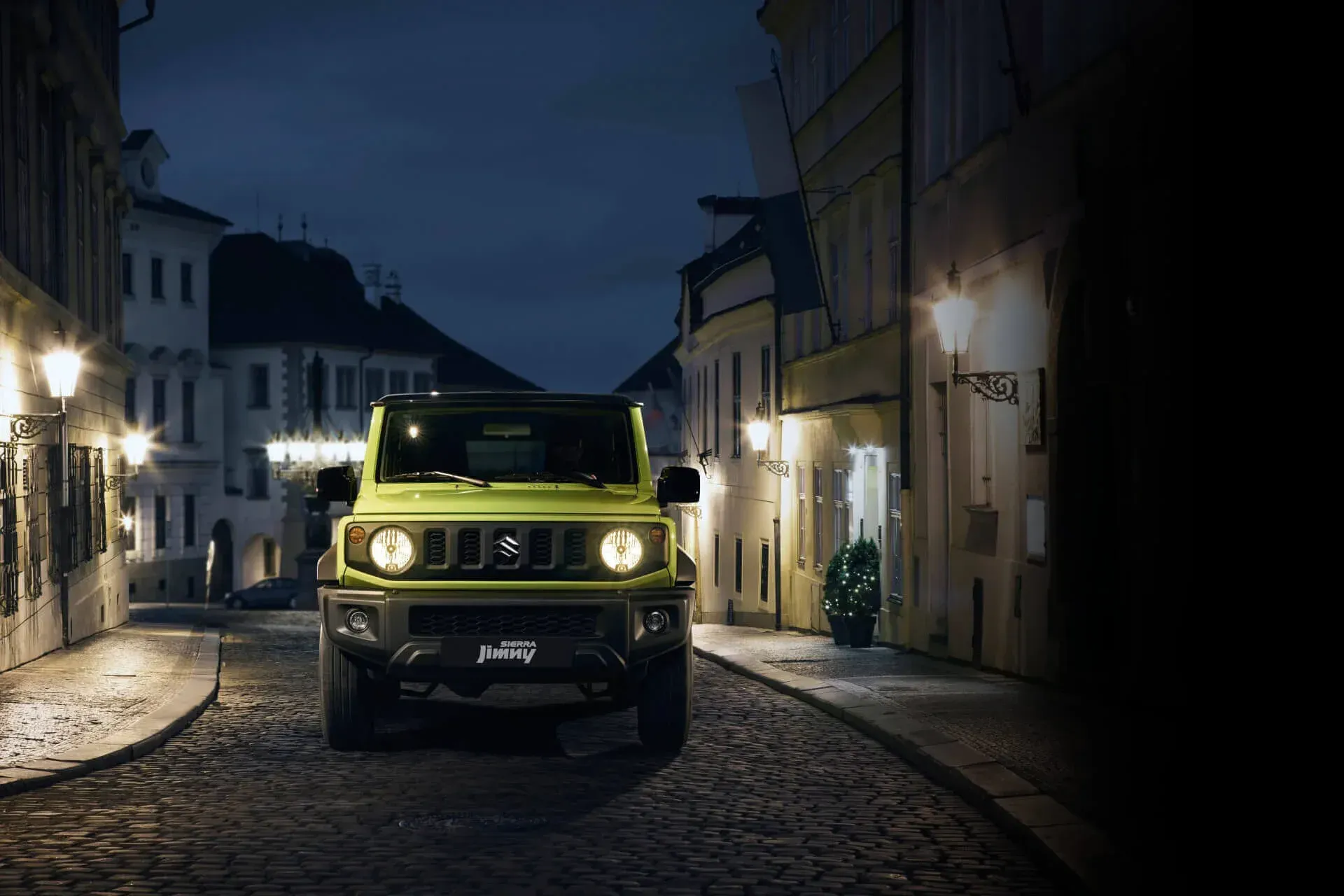 Um homem está trabalhando em um jipe ​​azul em um elevador em uma garagem.