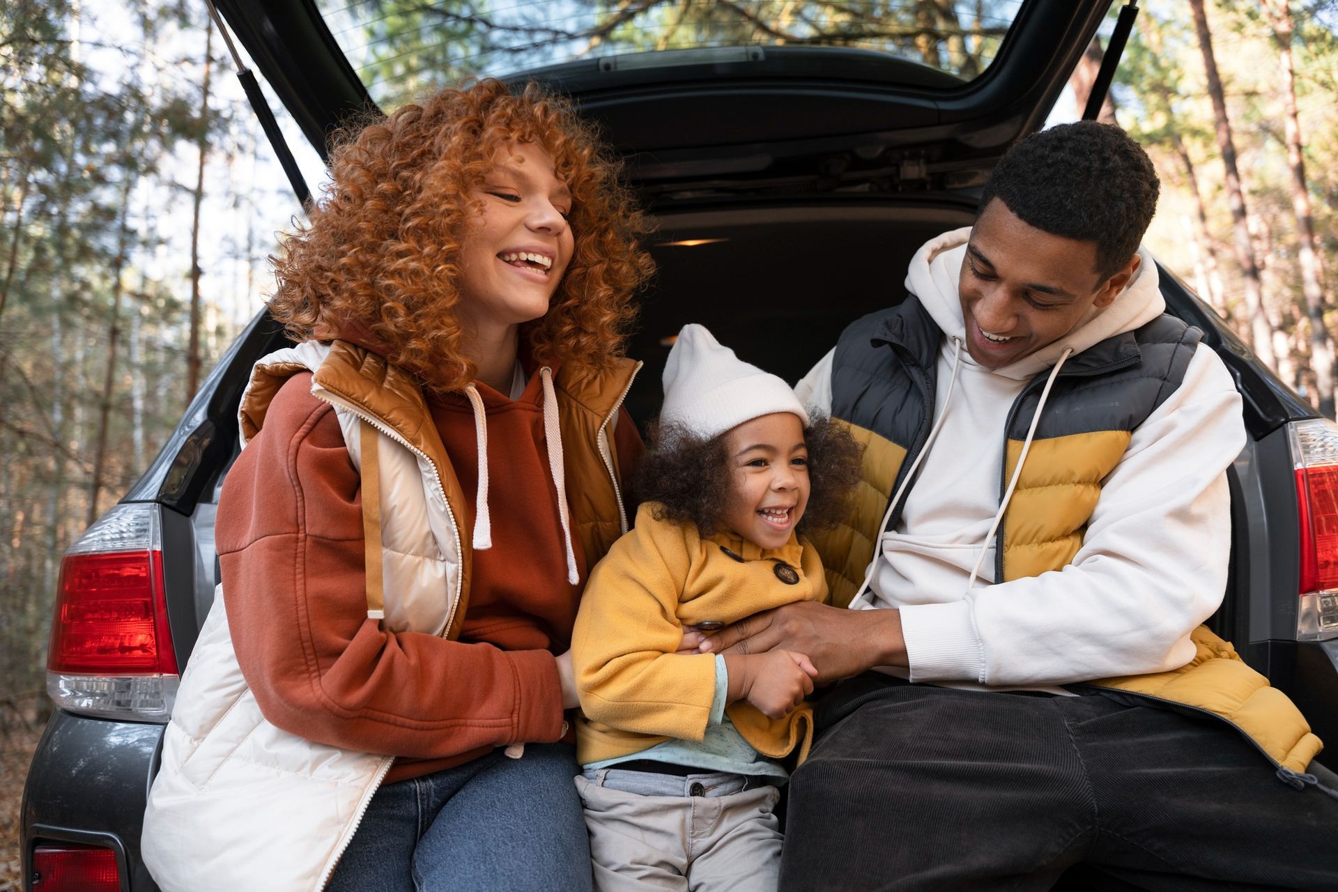 A family is sitting in the back of a car.