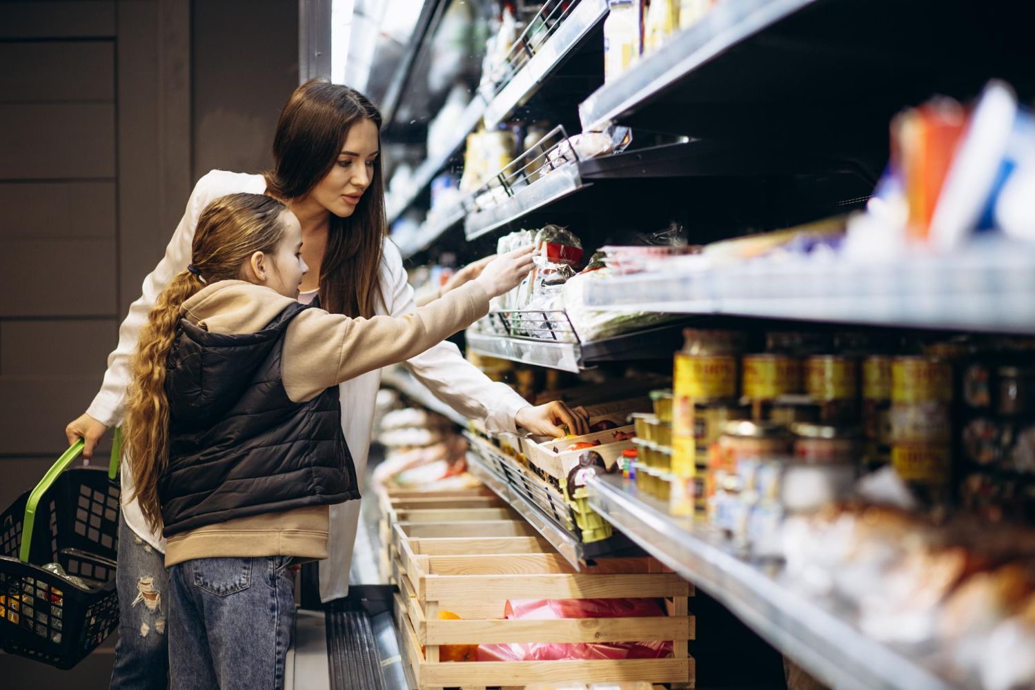 A mother and daughter are shopping in a grocery store.