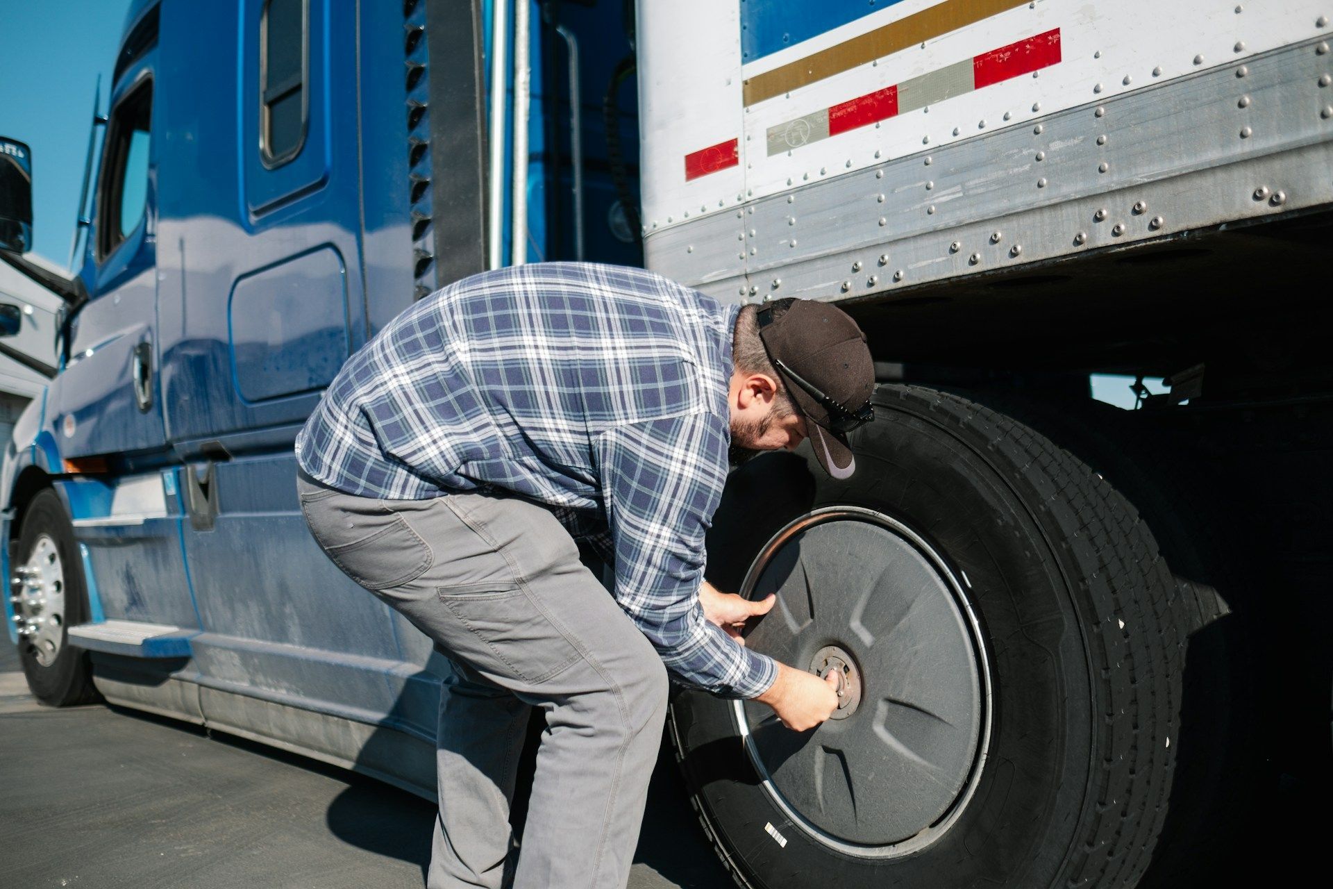 A man is changing a tire on a semi truck.