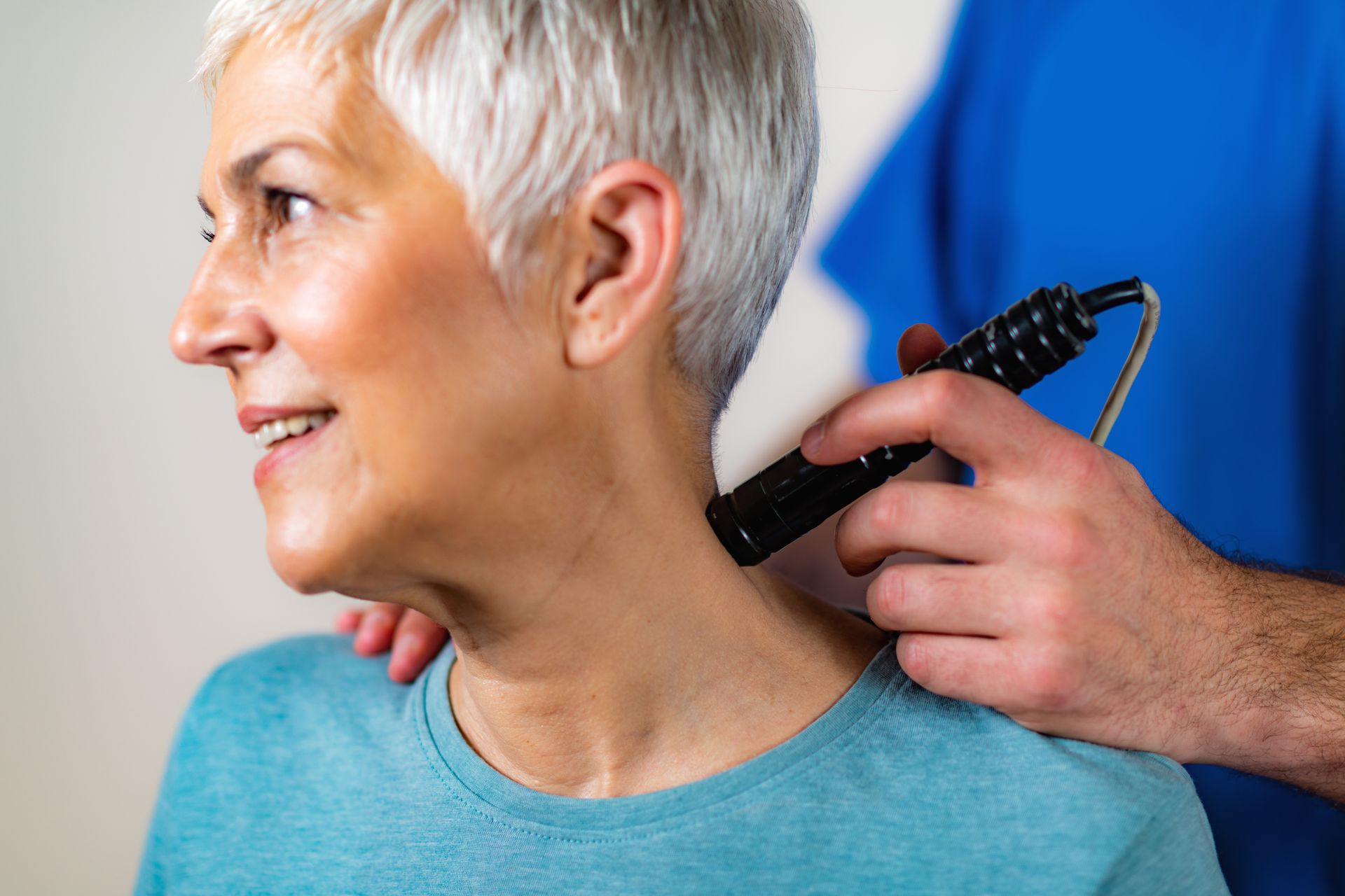 A woman is getting a massage on her neck by a doctor.