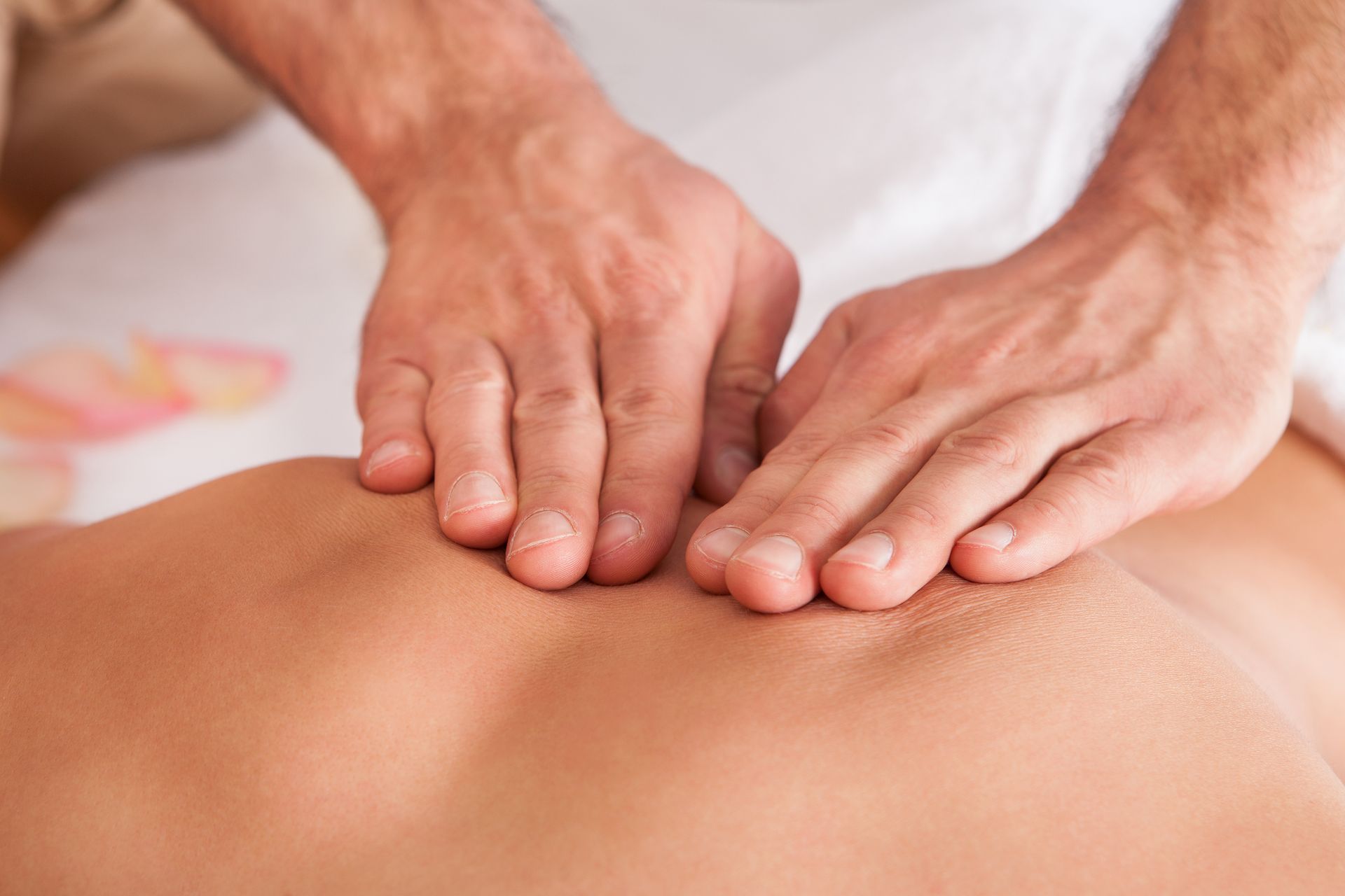 A man is giving a woman a massage on her back.