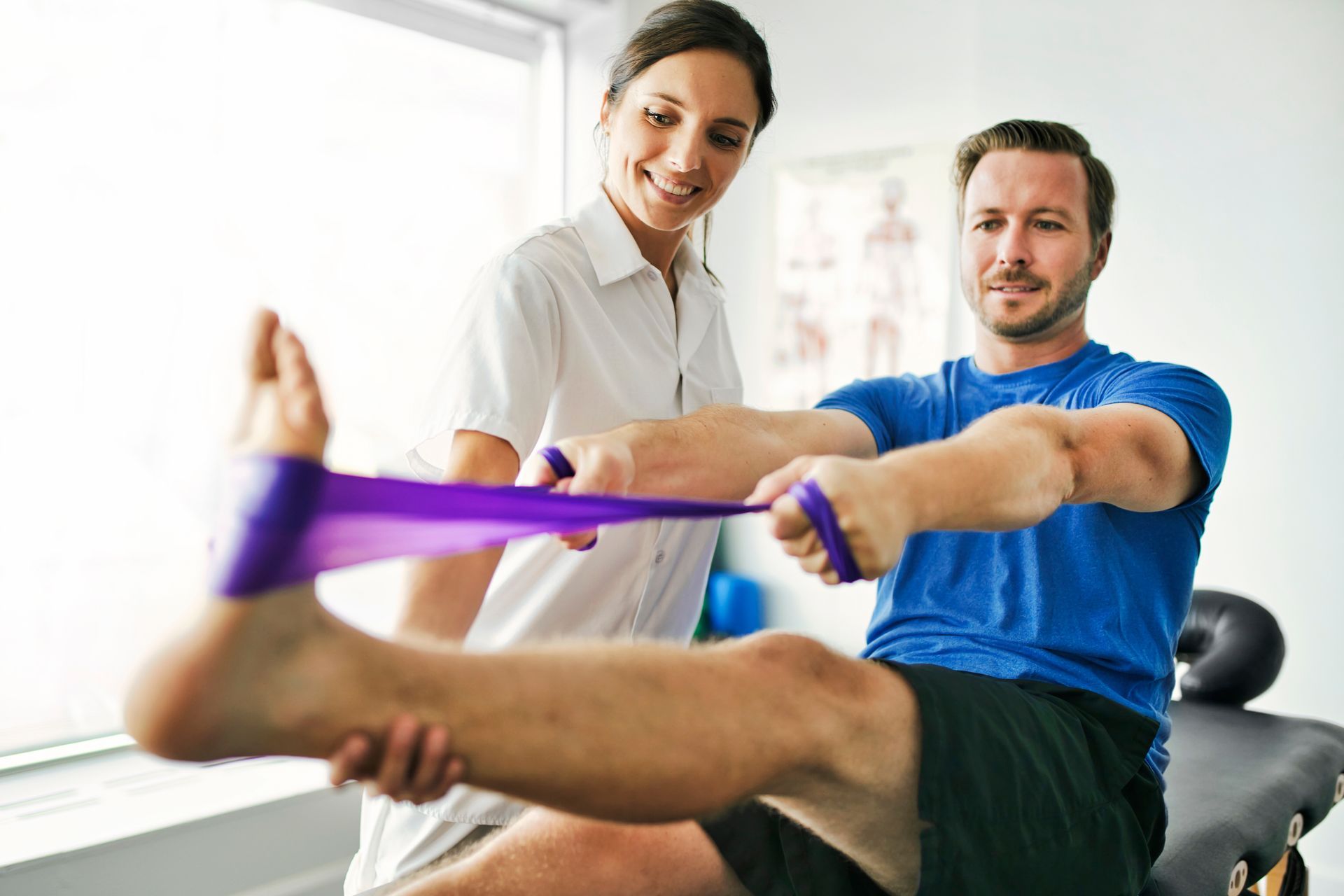 A man is being helped by a nurse with a resistance band.