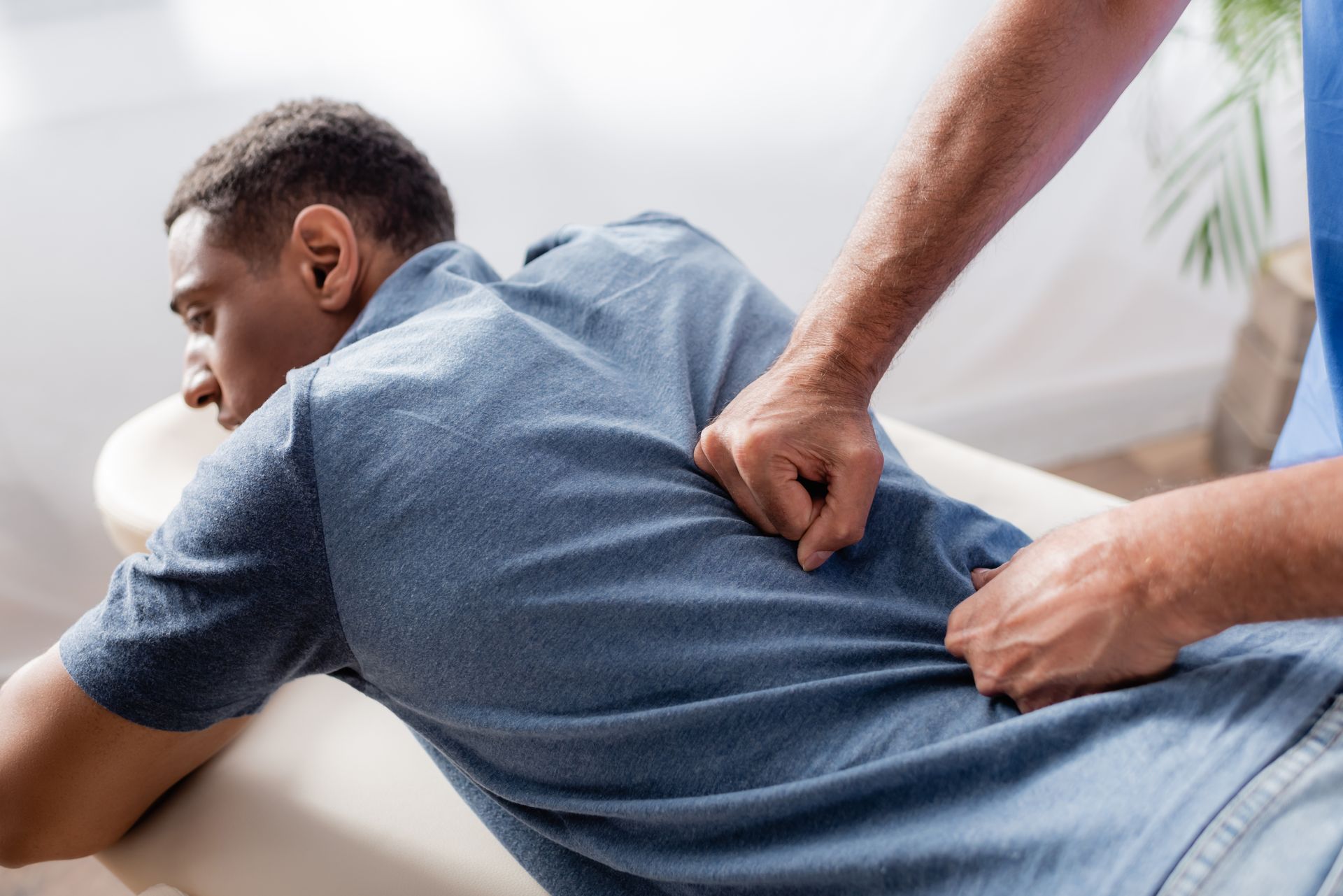 A man is getting a back massage from a doctor.