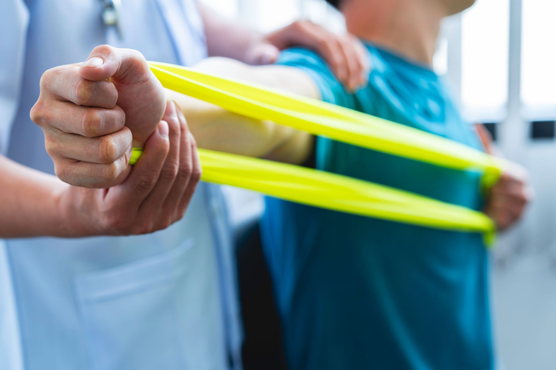 A man is doing exercises with a yellow resistance band.