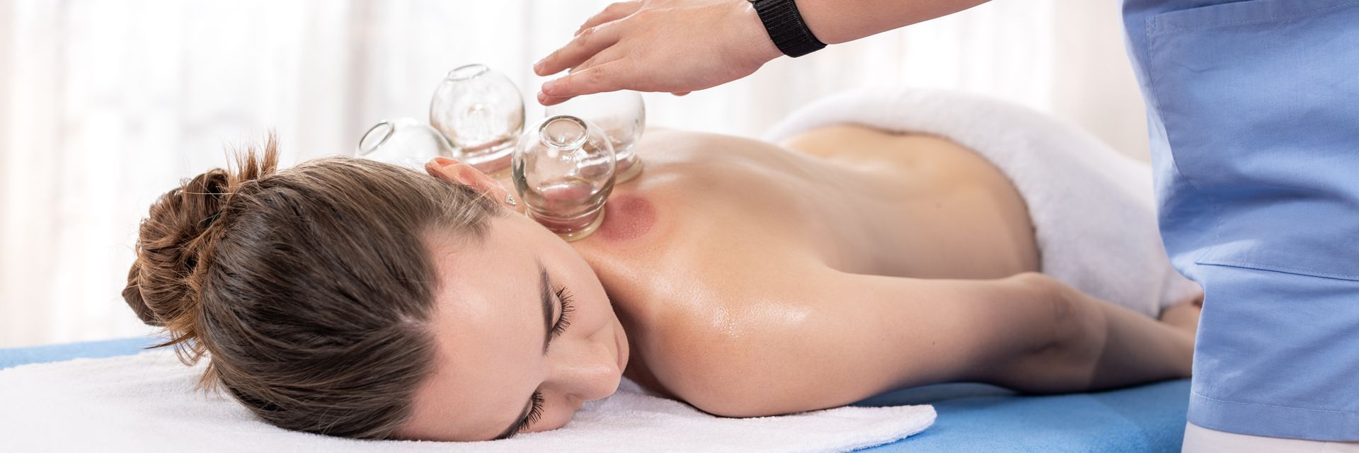 A woman is getting a cupping treatment on her back.