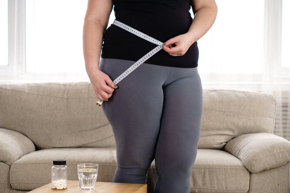 donna obesa mentre misura la vita