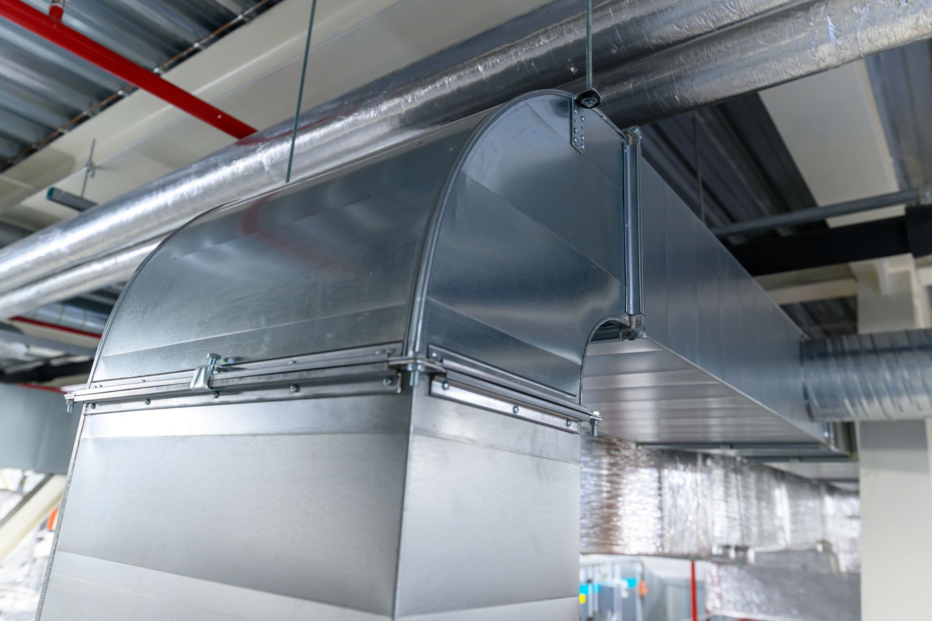 A large metal pipe is hanging from the ceiling of a building.
