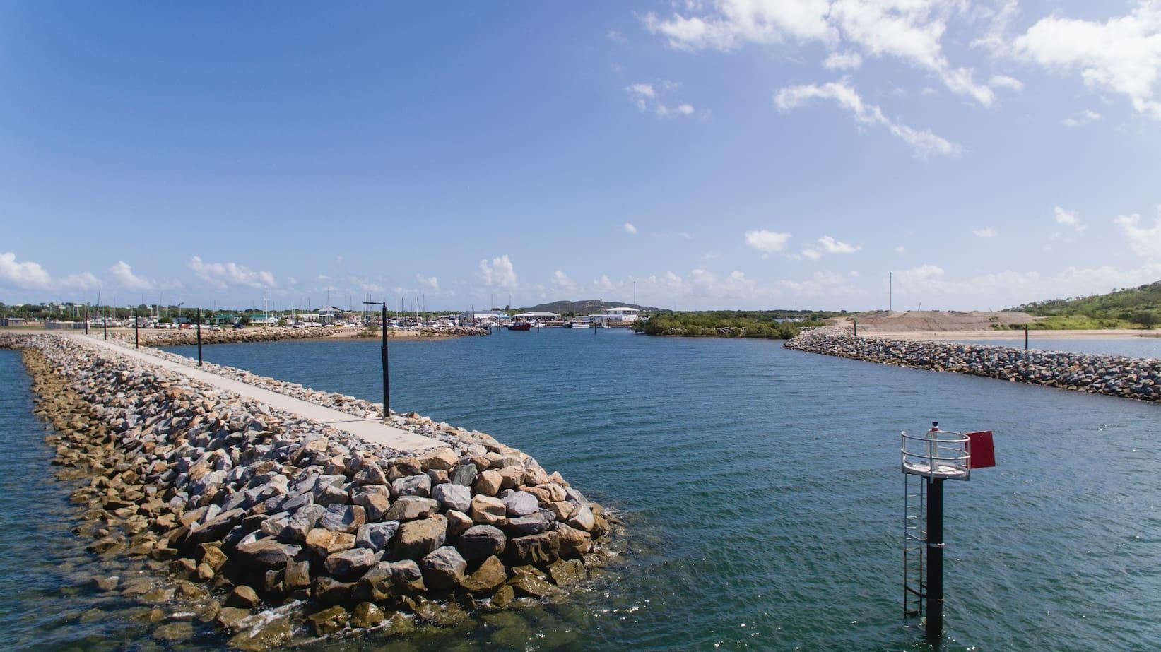 A Large Body of Water Surrounded by A Stone Wall and A Red Buoy — Hillery Group in Bowen, QLD