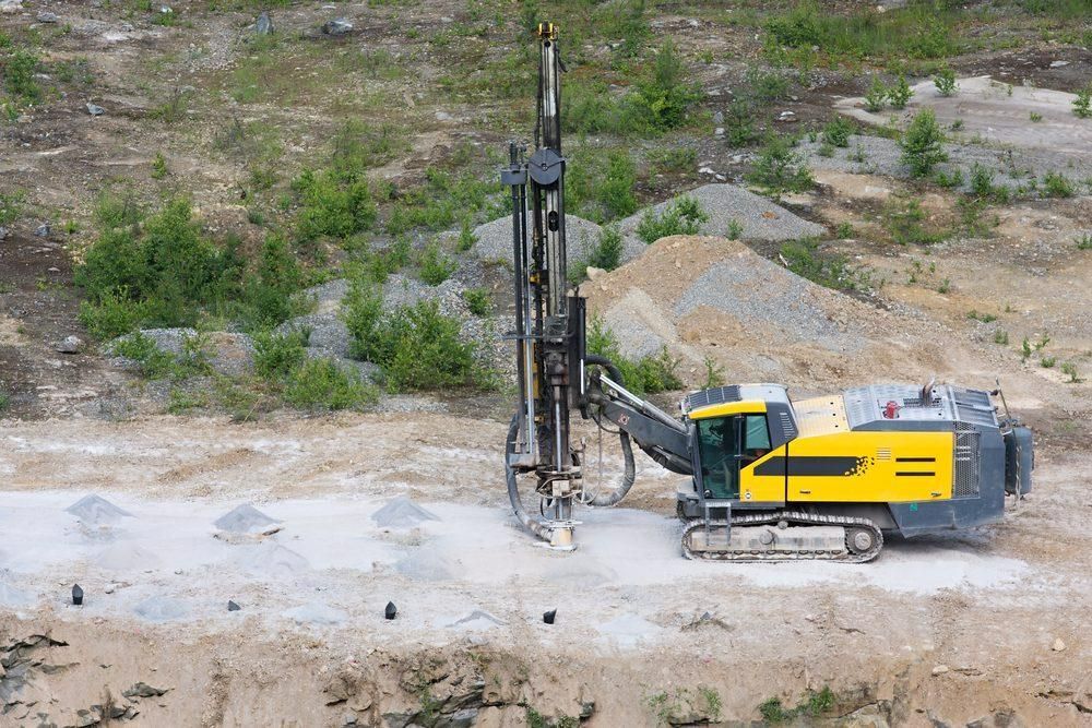 A Yellow and Black Machine Is Drilling a Hole in The Ground — Hillery Group in Bowen, QLD