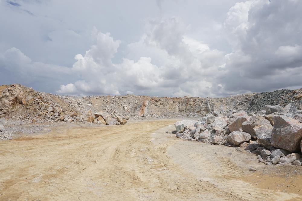 A Dirt Road Leading to A Large Pile of Rocks in A Quarry — Hillery Group in Bowen, QLD
