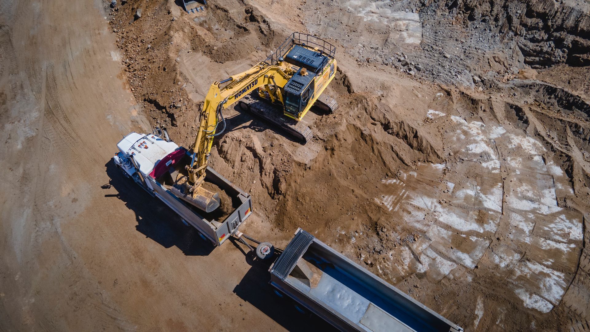 An Excavator Is Loading Coal Into a Dump Truck in A Coal Mine — Hillery Group in Bowen, QLD