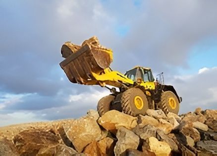 A Yellow Bulldozer Is Sitting on Top of A Pile of Rocks — Hillery Group in Bowen, QLD