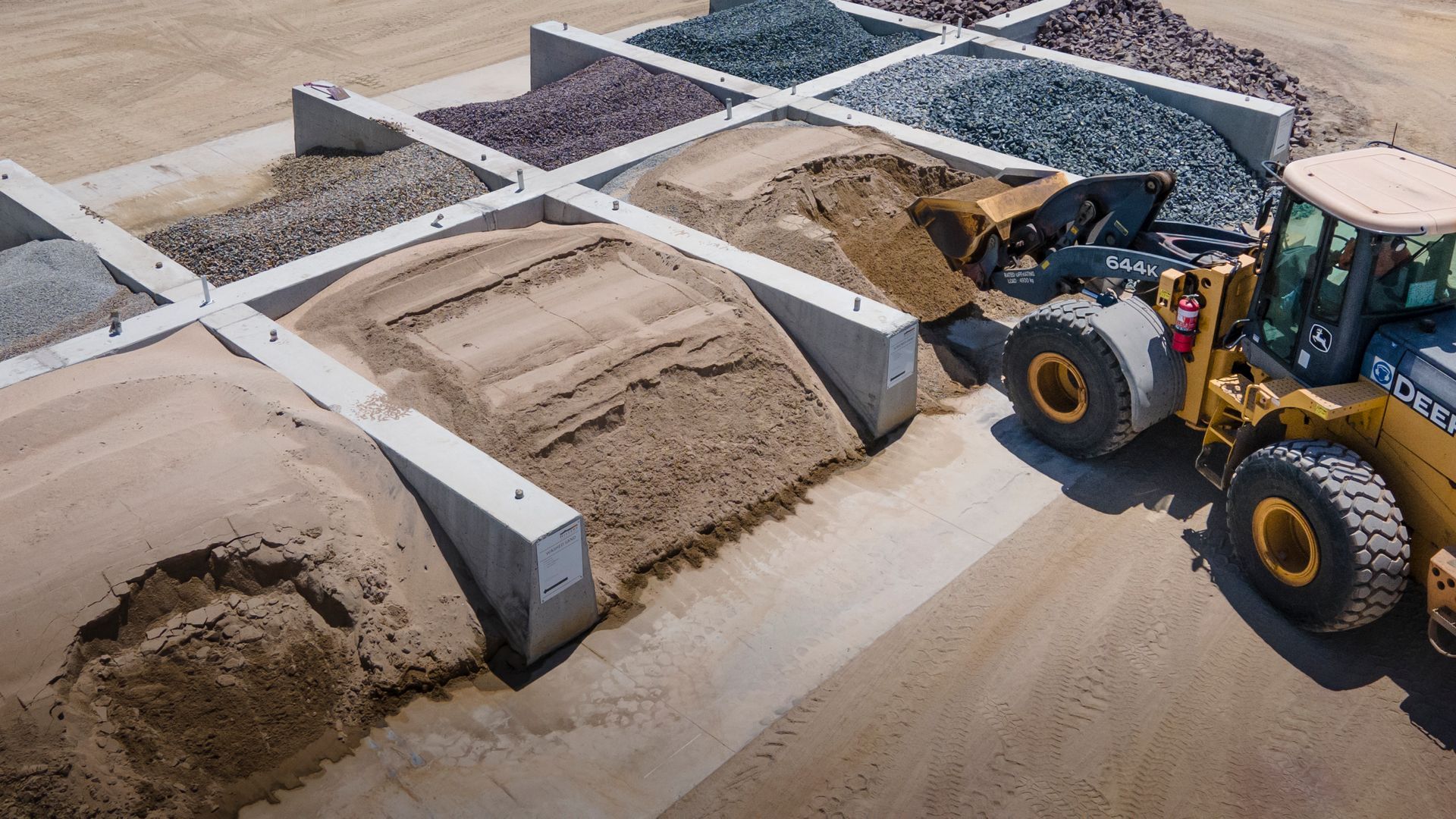 A Yellow Excavator Is Digging a Pile of Dirt in A Field — Hillery Group in Bowen, QLD
