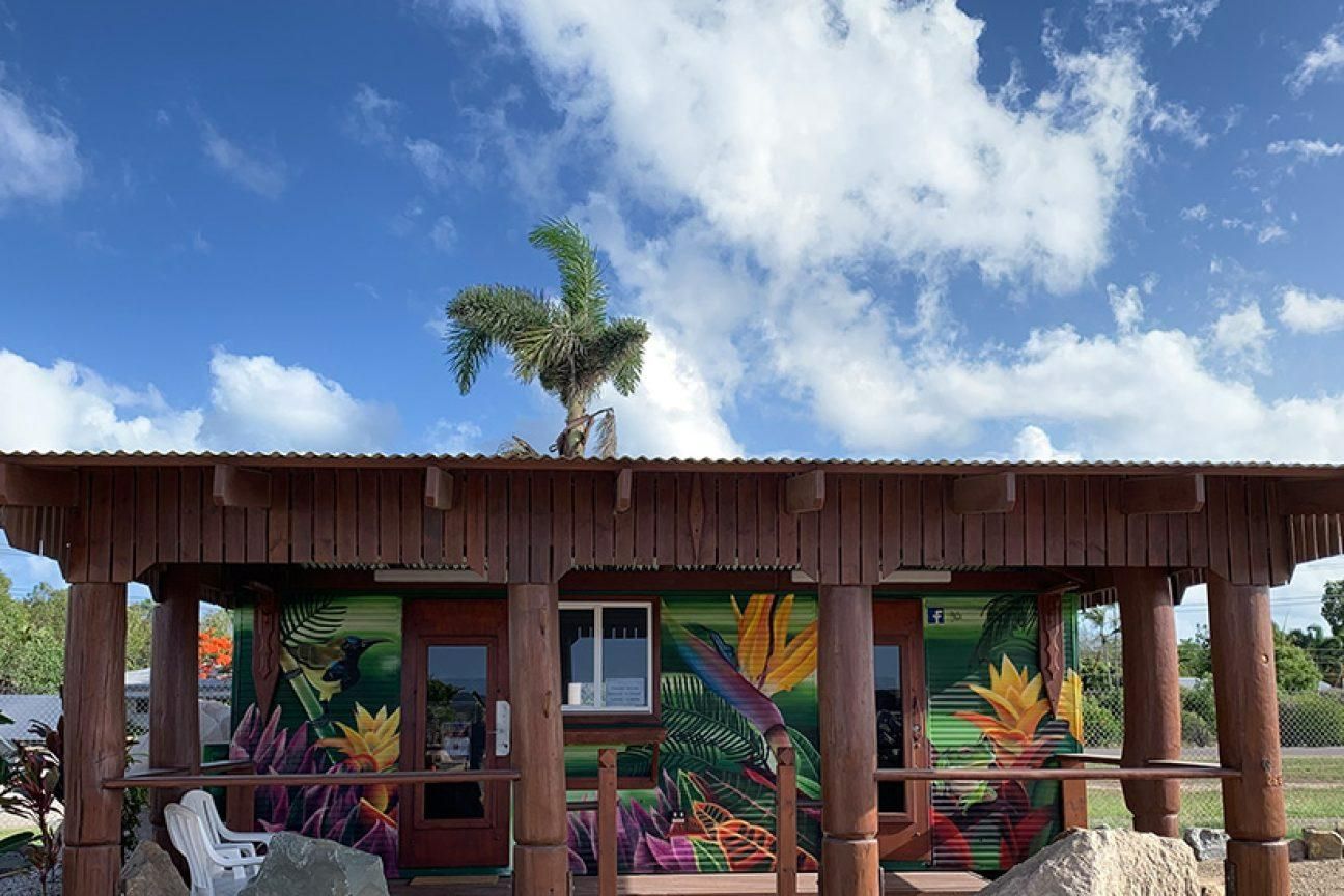 A Small Wooden House with A Painting on The Side of It — Hillery Group in Bowen, QLD