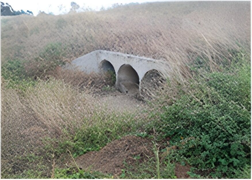 A Concrete Bridge in The Middle of A Grassy Field — Hillery Group in Bowen, QLD