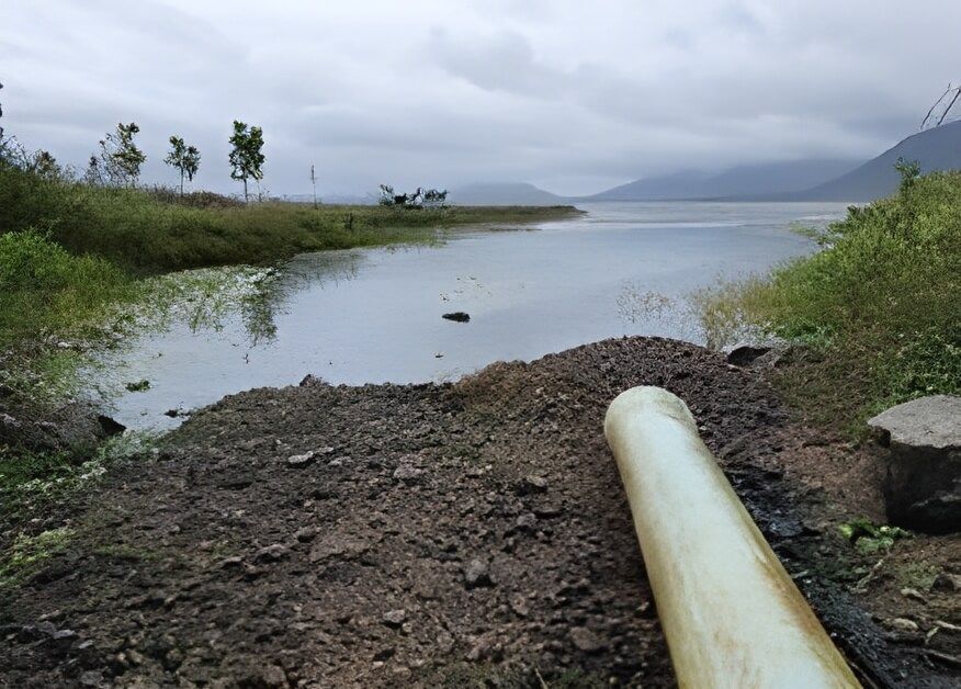 A Pipe Is Sitting on The Ground Next to A Body of Water — Hillery Group in Bowen, QLD