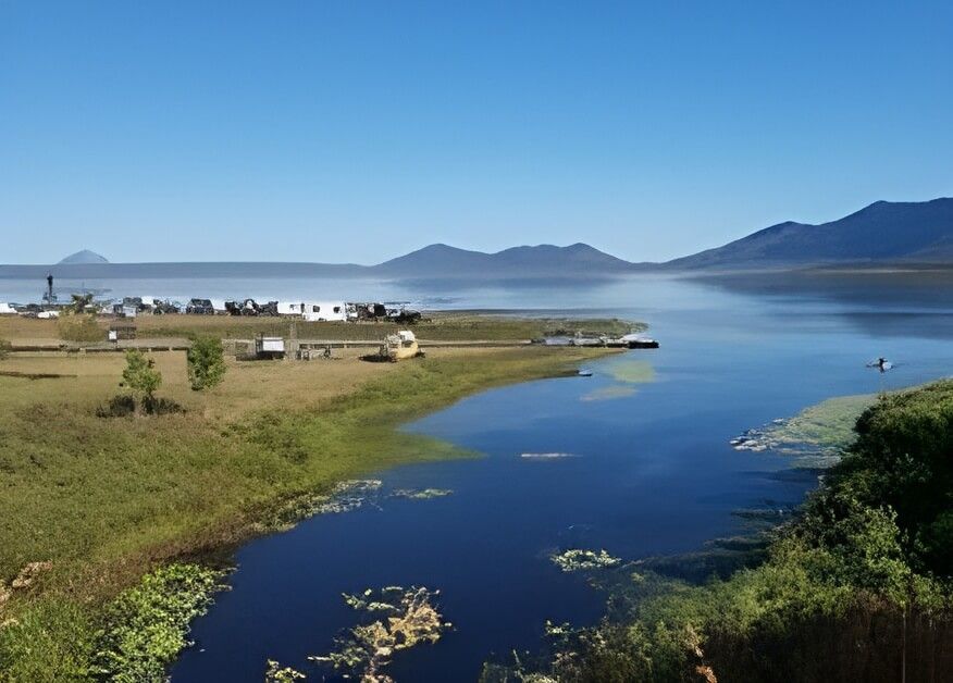 A Large Body of Water Surrounded by Grass and Trees with Mountains in The Background — Hillery Group in Bowen, QLD
