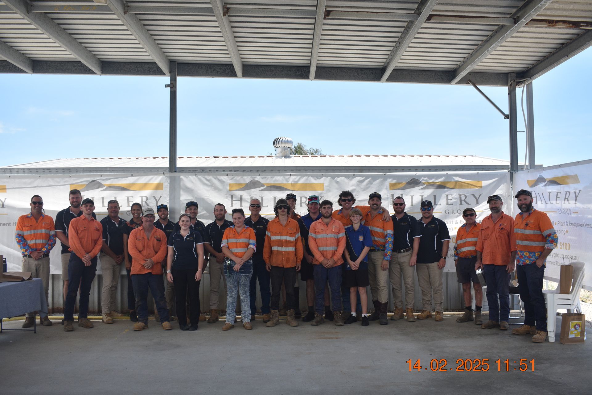 A Group Of Construction Workers Are Posing For A Picture Under A Canopy — Hillery Group in Bowen, QLD