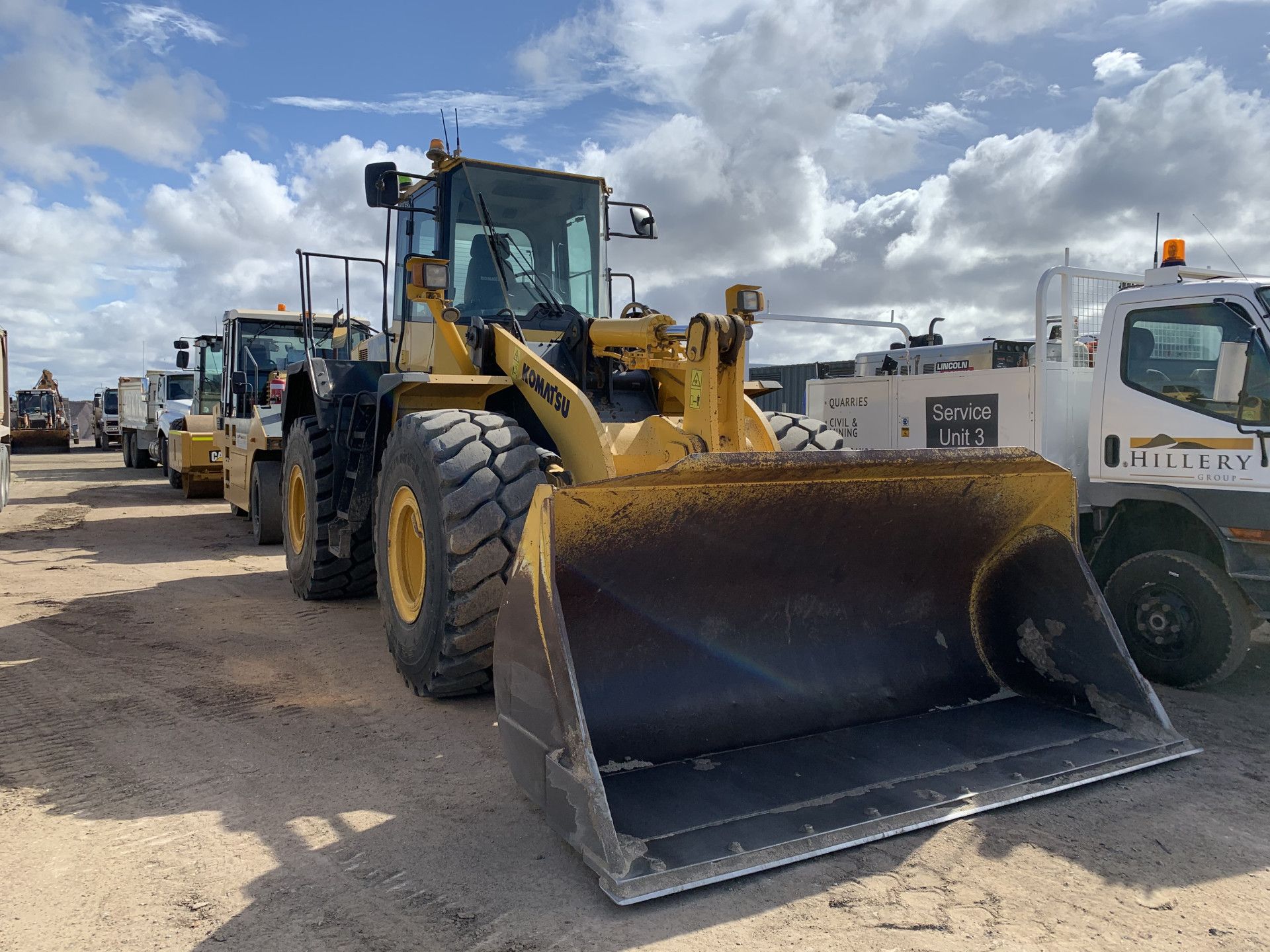 A Man Is Driving a Dump Truck in A Dirt Field — Hillery Group in Bowen, QLD