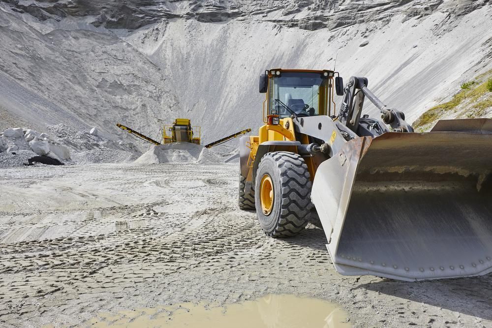 A Bulldozer is Driving Down a Dirt Road in a Quarry — Hillery Group in Bowen, QLD