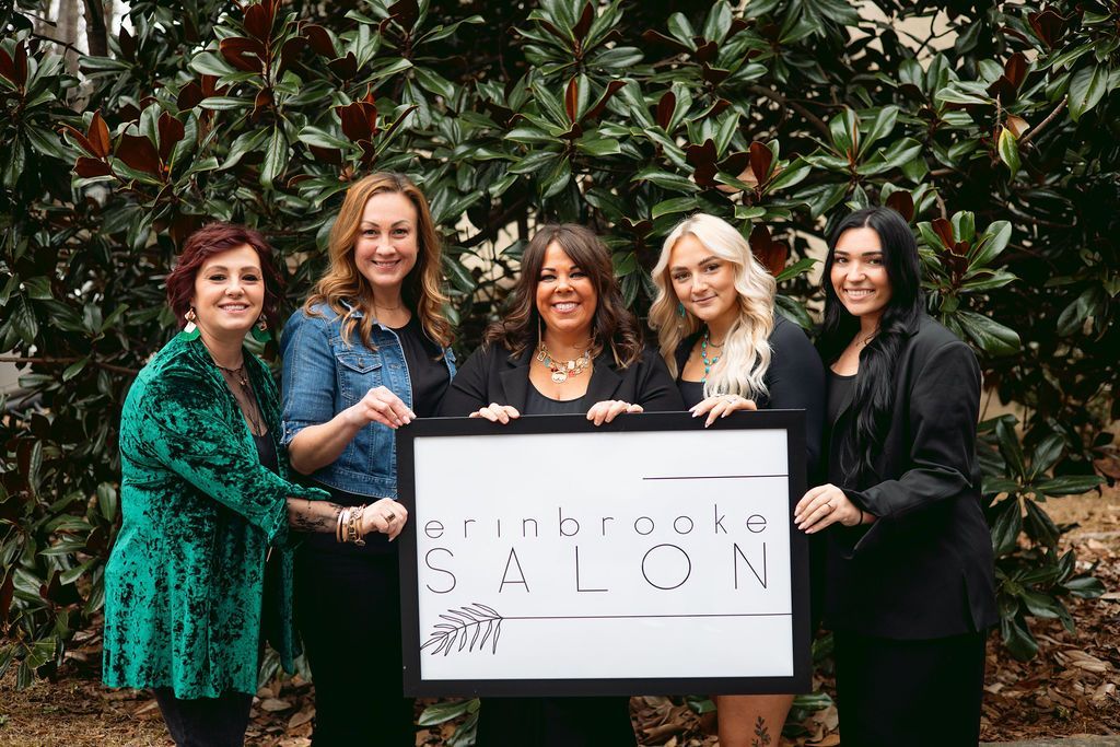 Five people holding a sign that says 