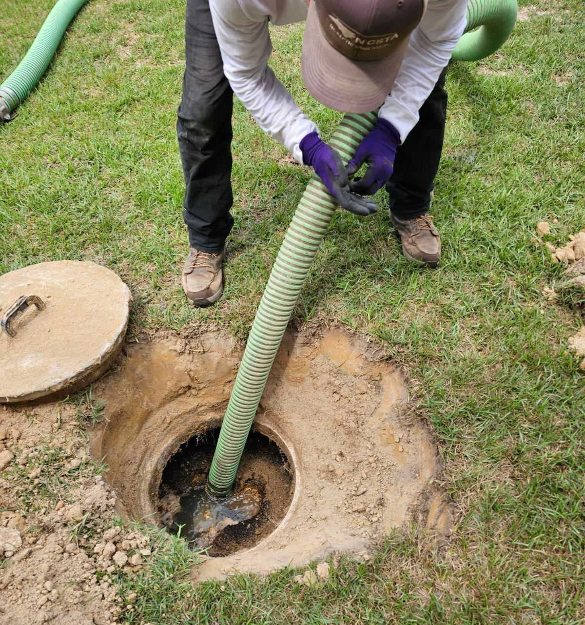 A hose is coming out of a hole in the ground.