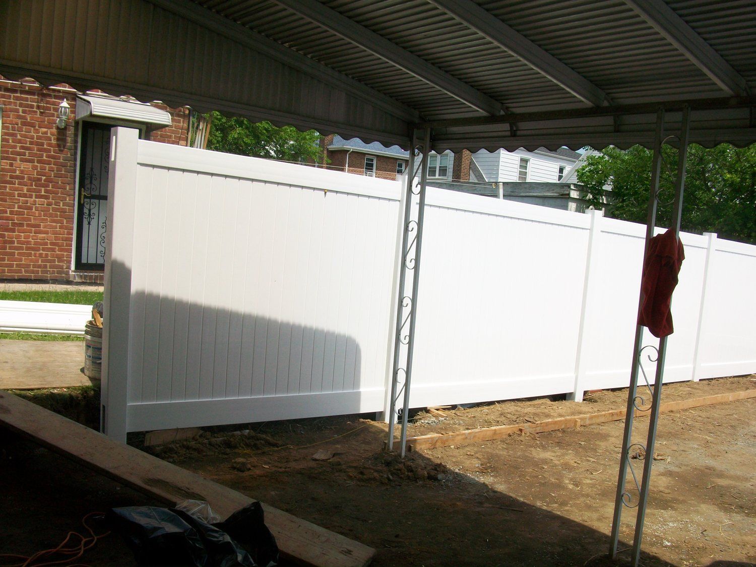 A white fence with a red mop hanging from it