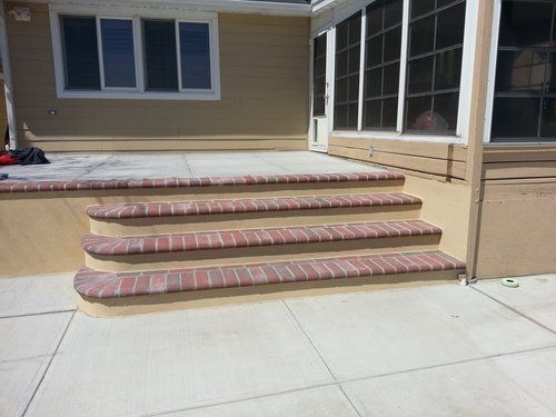 A set of brick steps leading up to a screened in porch