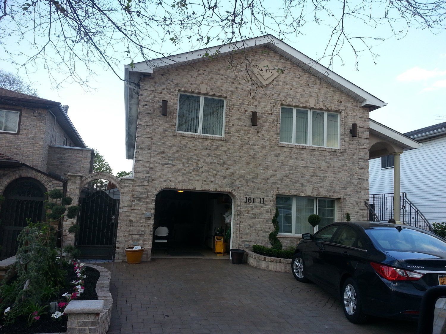 A brick house with a car parked in front of it