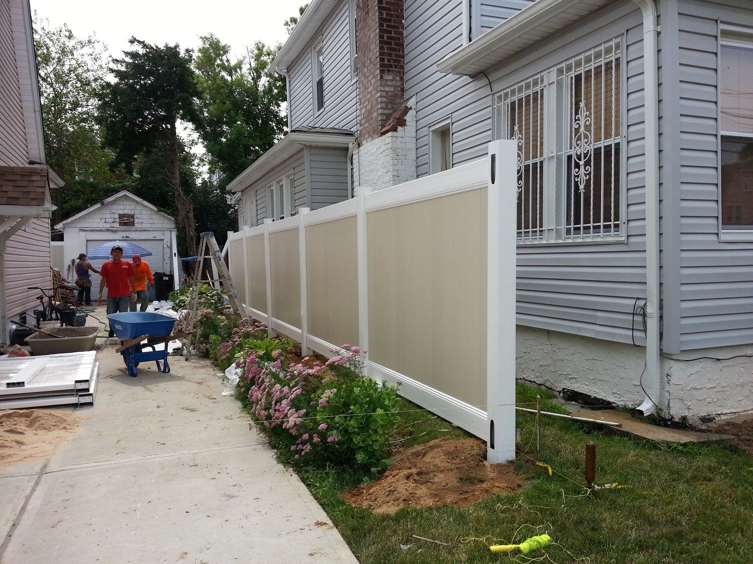 A fence is being built in front of a house