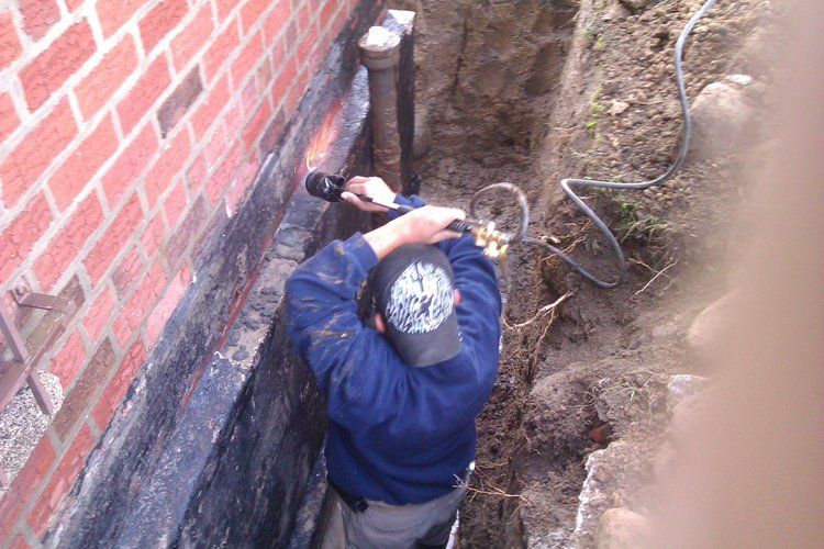 A man is working on a brick wall with a drill.