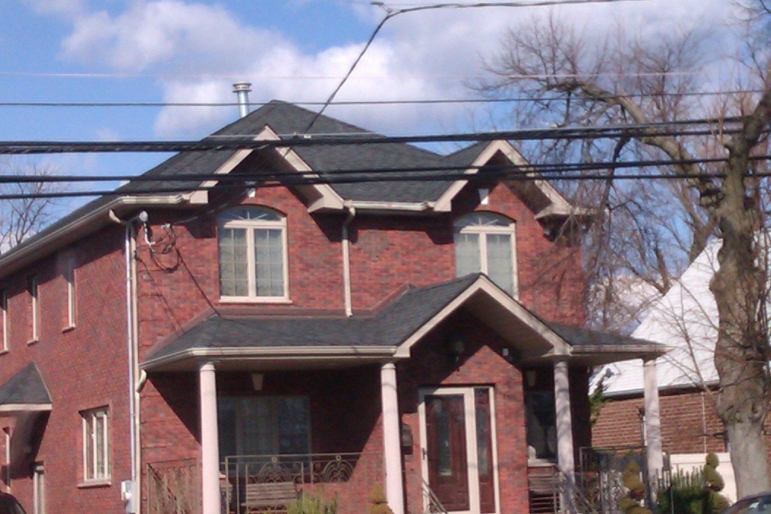 A large red brick house with a black roof