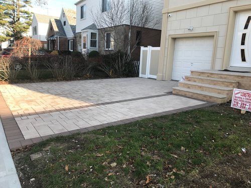A driveway in front of a house with a sign that says `` for sale ''.