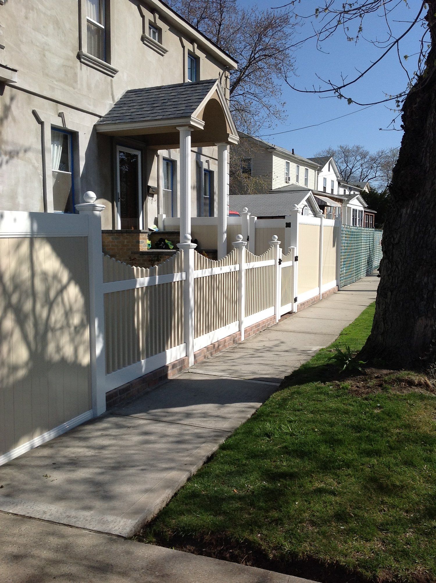 A white picket fence along a sidewalk in front of a house