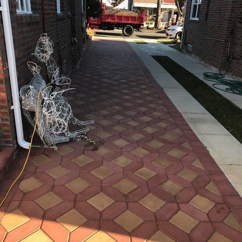 A brick walkway with a red dump truck in the background