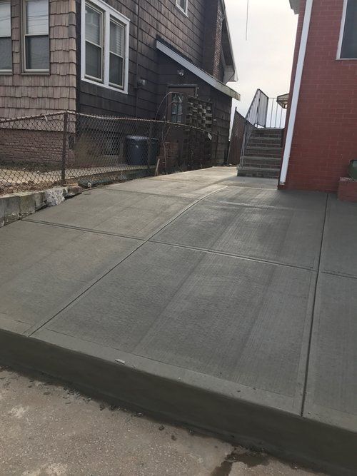 A concrete sidewalk is being built in front of a house.