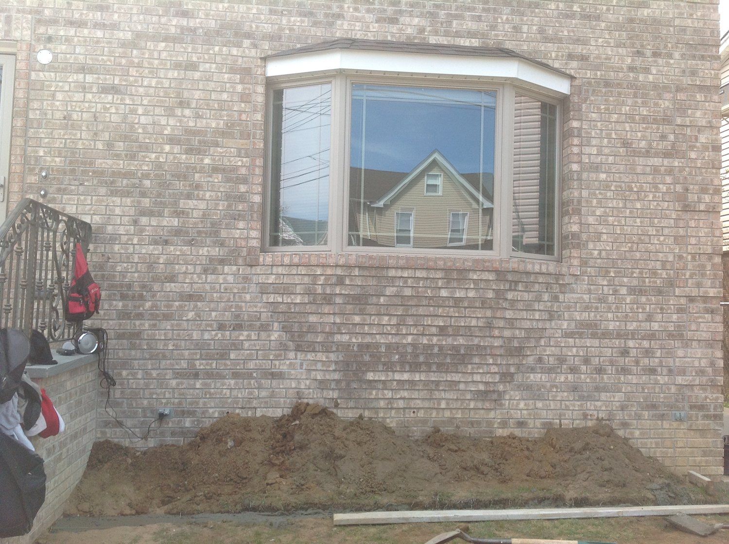 A brick building with a large window and a pile of dirt in front of it