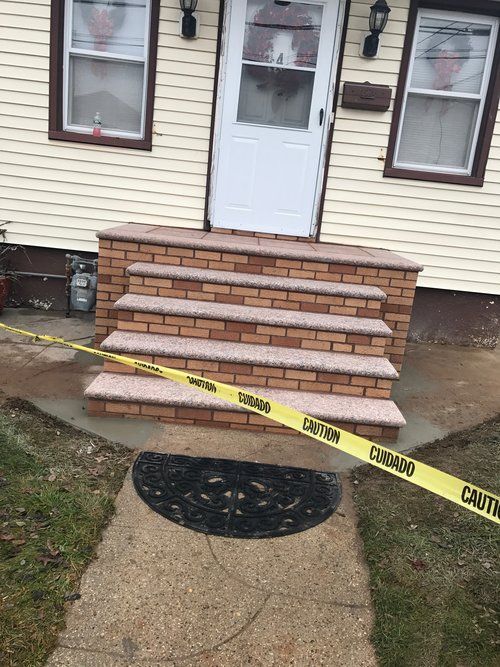 A brick porch with a yellow caution tape around it.