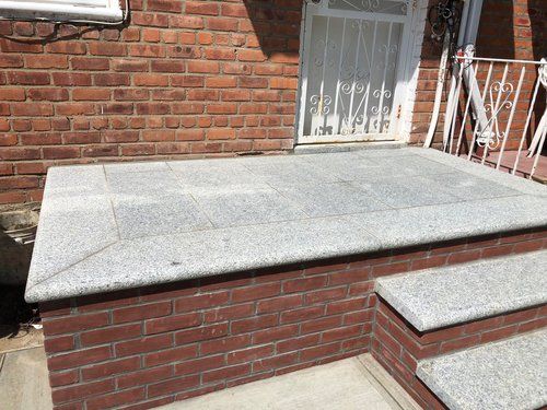 A brick building with stairs and a granite step